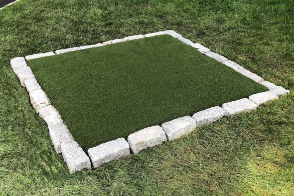 Flagstaff Tee box made of synthetic grass surrounded by stone border